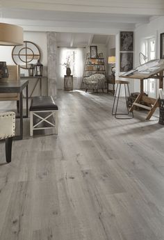 a living room filled with lots of furniture and decor on top of hard wood flooring