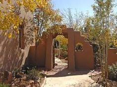 an adobe - style house in the desert surrounded by trees