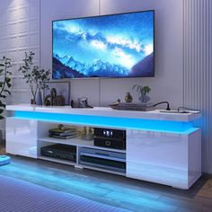 a flat screen tv sitting on top of a white entertainment center in a living room