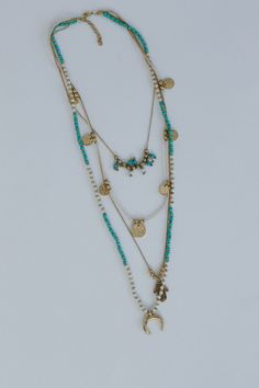 A unique addition to your neckline and perfect boho accessory is the Dreamscape Layered Necklace, you're sure to make a statement with this eye-catching and playful piece! Long statement necklace including 4 beautiful layers Stunning silhouette with statement colors including off white, turquoise, pearl, and gold beading So CUTE Gold charms including textured gold disks, hamsa hand, and crescent horn Classic lobster claw closure with a 2" extender Pair with: Evermore Seamless Lace Racerback Bral Turquoise Multi-strand Necklace For Festivals, Bohemian Gold Layered Beaded Necklaces, Gold Layered Bohemian Beaded Necklaces, Turquoise Multi-strand Necklaces For Layering, Turquoise Multi-strand Bohemian Necklace, Bohemian Gold Turquoise Necklace For Beach, Bohemian Turquoise Necklace For Beach, Turquoise Multi-strand Beaded Necklace For Festivals, Turquoise Bohemian Beaded Necklaces For Layering