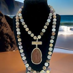 The Beachcomber necklace is a perfect way to bring the ocean's magic into your everyday look. Adorned with beads, stones, and crystals in calming colors, it evokes the peaceful beauty of the beach at dawn. The 33-inch length and versatile pendant make it the perfect accessory for any occasion. Imagine the joy of a day at the beach, everywhere you go! Bohemian Beaded Agate Long Necklace, Bohemian Agate Beaded Long Necklace, Bohemian Long Agate Beaded Necklace, Bohemian Long Beaded Stone Necklace, Bohemian Necklaces With Stones For Meditation, Bohemian Long Beaded Necklaces With Stones, Natural Stones Mineral Crystal Jewelry For Meditation, Bohemian Long Necklace With Natural Stones For Beach, Bohemian Beaded Necklaces For Healing