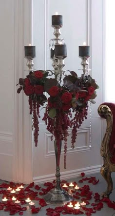 a fancy candelabra with candles and flowers on the floor in front of it