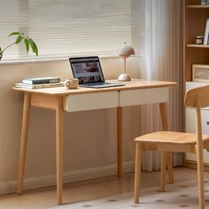 a laptop computer sitting on top of a wooden desk next to a book shelf and chair