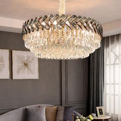 a living room filled with furniture and a crystal chandelier hanging from the ceiling