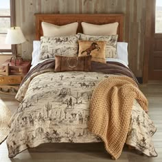 a bed with pillows and blankets on it in front of a wooden headboard wall