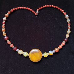 This necklace is made of round carnelian beads is such a dold and stunning necklace on, with edgy artisan appeal. In the center of the necklace is a large flat bead 1 cm high. This necklace can be worn by stylish men and women.      Such a dold statement maker, unique and very artisan. So stunning on, ful of vibrant light and color, reflection, this is day every day necklace yoif looking for - with jeans and a blouse, or dressed up, it goes with everything, enjoy.       Carnelian is known to sti Hand-strung Round Beads Choker As Gift, Hand-strung Round Beads Choker For Gift, Gift Round Beads Hand-strung Choker, Gift Hand-strung Round Beads Choker, Adjustable Natural Stones Round Beads Choker, Adjustable Choker With Natural Stones And Round Beads, Adjustable Natural Stones Choker With Round Beads, Spiritual Beaded Necklace With Round Natural Stone Pendant, Unique Hand-strung Orange Necklace