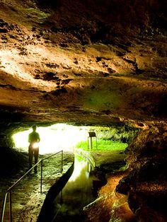 two people standing in the entrance to a cave