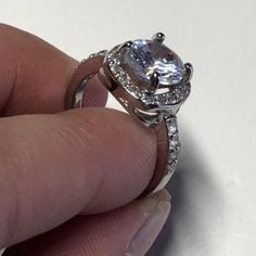 This ring is FULL OF BLING! Sterling Silver Plated Ring with white cubic zircon stones. Square set surrounded by small white cubic zircon stones stacked with a 2 CT cushion cut center white cubic zirconia stone. Channel setting. This is a SIZED ring, please see available sizes. VIDEO: https://www.facebook.com/wickedwondersVIPbling/vid... #Princess #Bling #RingBling Diamond White Rings With Accent Stones, Cubic Zirconia White Gold Diamond Ring For Promise, Dazzling White Diamond Ring With Center Stone, White Rings With Diamond Accents And Round Stone, Dazzling Cubic Zirconia Diamond Ring With Halo Setting, Dazzling Crystal Ring With Halo Setting, Cubic Zirconia Halo Ring With Center Stone, White Gold Cubic Zirconia Diamond Ring, Rings With Halo Setting And Cubic Zirconia Round Cut