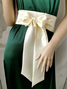 a mannequin wearing a green dress with a white bow on it's belt