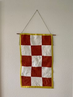 Handmade quilted wall hanging, checkered print created with scrap pieces of hand dyed red linen and white linen fabric.  Backing is hand dyed cotton.  Hanging is connected to a wooden stick by thread and hung with braided embroidery thread. Braided Embroidery, Quilt Tapestry, Sewing Products, Quilt Wall Hanging, White Linen Fabric, Quilted Wall Hanging, Textile Wall Hangings, Quilt Wall, Fabric Wall Hanging