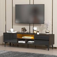 an entertainment center with a flat screen tv mounted on it's side, in front of a beige wall