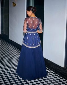 Embrace exquisite elegance in this midnight blue hand-embroidered asymmetric peplum ensemble! Intricately adorned with sequins, stones, and beads, this peplum exudes opulence and charm. The v-neckline and handmade tassels at the sleeves add a touch of sophistication. Paired with a flowy georgette skirt and a matching net dupatta, this ensemble offers a perfect blend of grace and allure. Elegant Peplum Set In Georgette, Elegant Georgette Peplum Set, Blue Embellished Evening Set, Embellished Blue Evening Sets, Anarkali Embellished Peplum Sets, Anarkali Sets With Embellished Peplum, Blue Sequined Party Wear Sets, Elegant Peplum Sharara In Georgette, Traditional Embellished Peplum Dress