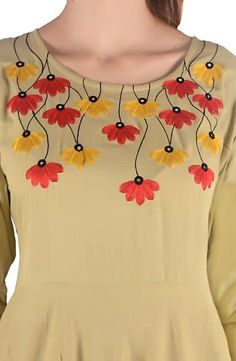 a woman wearing a yellow dress with red and yellow flowers on it's chest