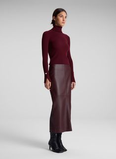 The Jett Top is crafted from stretch merino wool in a burgundy hue. This long-sleeve silhouette features a foldover turtleneck and two sleek slits placed along the sleeves. Shop Tops. Styling Tip: Wear with tailoring for the day and a fluid skirt to transition to evenings. Burgundy On Burgundy Outfit, Leather Skirt Design, Maroon Leather Outfit, Burgundy Tops For Women, Brown Leather Maxi Skirt Outfit, Burgundy Skirt Outfit Summer, Casual Winter Outfits Skirt, Burgundy Sweater Vest Outfit, All Burgundy Outfit