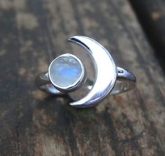 Handmade, Natural Rainbow Moonstone Sterling Silver Ring 💙Featured in this listing are sterling silver, handmade, natural stone rings. These lovely rings feature a beautiful, Natural Rainbow Moonstone 7mm round stone. The Glowing stone has been bezel set into a handcrafted, adjustable setting made with all highly polished Sterling Silver. A handcrafted Crescent Moon sits aside the Moonstone and is 11x15mm. Each Rainbow Moonstone has been handpicked, and have amazing flash! 🌜Please keep in mind Adjustable Celestial Moonstone Ring, Adjustable Crescent Moonstone Promise Ring, Sterling Silver Moon Charm Ring, Silver Celestial Moonstone Ring, Silver Moon-shaped Celestial Moonstone Ring, Celestial Silver Moonstone Ring, Adjustable Crescent Moonstone Ring, Silver Crescent Moonstone Ring In Celestial Style, Adjustable Celestial Sterling Silver Crystal Ring