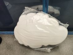 a white object wrapped in plastic sitting on the ground