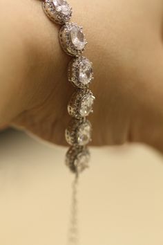 Elegant bridal bracelet made with Cubic Zirconia set in rhodium silver plated settings .6 inches long with a 2 inch extension chain and lobster clasp. Matching bracelet available at this link: https://www.etsy.com/listing/177345488/bridal-earrings-cubic-zirconia-earrings?ref=shop_home_active_1 Please contact me if you like more then one. Thank you for visiting SimplyChic93 Wedding Bracelets With Handset Crystal Stones, Wedding Crystal Bracelets With Handset Stones, Adjustable Cubic Zirconia Jewelry For Formal Occasions, Crystal Bracelets With Handset Stones For Wedding, Dazzling White Gold Crystal Bracelet For Wedding, White Gold Crystal Bracelet With Sparkling Stones For Wedding, Elegant Silver Crystal Bracelet With Bling, Wedding Jewelry With Bling And Round Shape, Round Sparkling Jewelry For Wedding