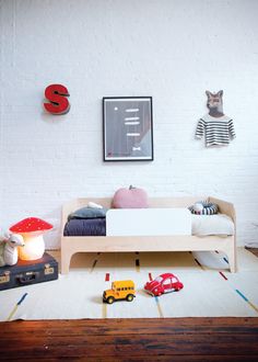 a child's bedroom with toy cars and toys on the floor in front of it