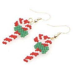 two red and green beads are hanging from earrings