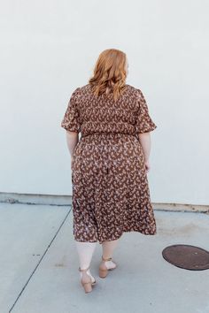 Stay stylish with the Emsley Midi dress! Featuring a charming brown color with delicate white florals, this dress is designed with a smocked bodice and flared bubble sleeves for a fun and flattering look. Plus, it has pockets for added convenience. Look effortlessly chic in this must-have dress! The Emsley Midi is lined. Fits true to size. Model is wearing a small and is 5'10". Plus model is wearing a 2X and is 5'6". Size Chart Length Bust Waist S 46" 30" 28" M 46" 32" 30" L 47" 34" 32" XL 48" 3 Brown V-neck Dress For Garden Party, Casual Brown Midi Dress With Smocked Back, Brown Modest Midi Dress For Spring, Modest Brown Midi Dress For Spring, Brown Dress With Smocked Bodice And Short Sleeves, Casual Brown Midi Dress With Ruffle Hem, Casual Brown Midi Dress With Smocked Bodice, Brown Short Sleeve Dress With Smocked Bodice, Brown Flutter Sleeve Dress For Spring