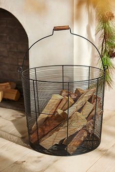 a basket filled with bread sitting on top of a wooden floor next to a fireplace