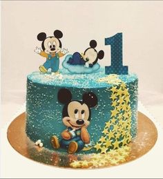 a mickey mouse birthday cake with blue frosting and gold stars on it, including the number one