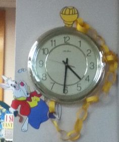 a clock that is on the side of a wall with yellow ribbon around it's edges