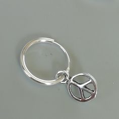 A PAIR of sterling silver hoops. Comes with a detachable tiny peace sign charm. The charm is multipurpose and can be used with a neck or bracelet chain too. Dimension: Hoop- mm Charm- mm Drop length- mm Price listed is for a PAIR of hoops. These earrings are made of 925 hypoallergenic sterling silver and comes with a 925 stamp. Can be packaged in a gift box. I can include a personal message from you if needed You are welcome to contact me at... bhavnakwintra1956@gmail.com For more beautiful piec Nickel-free Silver Huggie Septum Ring, Silver Pierced Huggie Septum Ring, Nickel Free Sterling Silver Huggie Cartilage Earrings, Nickel-free Sterling Silver Huggie Cartilage Earrings, Nickel Free Silver Metal Nose Rings, Silver Huggie Septum Ring, Nickel-free Sterling Silver Septum Ring, Nickel-free Silver Metal Nose Ring, Nickel-free Silver Metal Septum Ring