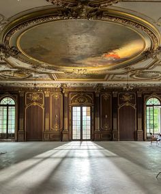 an empty room with many windows and paintings on the walls