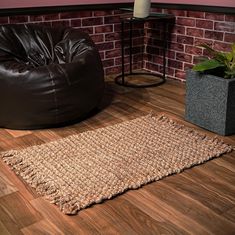 a brown bean bag sitting on top of a wooden floor next to a black chair