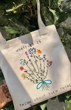 a white tote bag with flowers on it and the words whatever is think about such thing