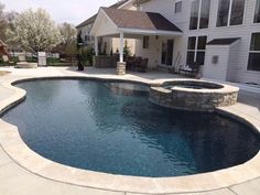 an outdoor swimming pool in front of a house