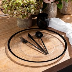 the table is set with black utensils and silverware, along with flowers