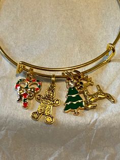 This expandable Christmas charm bracelet, made of gold over stainless steel. I also use double split jump rings (key chain rings) to prevent charm loss. These bracelets are expandable from 2.5 to 3 inches around, will fit  wrist up to 8.5. cute gift to add some holiday flair.  A great gift  or stocking stuffer . I hope you enjoy this as much as I enjoyed making it. Adjustable Novelty Charm Bracelet, Novelty Gold Metal Jewelry, Handmade Gold Charm Bracelet For Gift Making, Handmade Gold Charm Bracelet For Gift, Handmade Gold Charm Bracelet As Gift, Adjustable Nickel-free Charms As Gifts, Gold Charm Bracelet With Dangling Charms As Gift, Gold Novelty Bracelets With Charms, Personalized Gold Novelty Bracelets