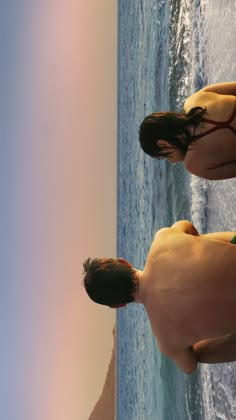 two people in bathing suits standing on the beach