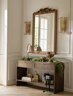 a mirror sitting on top of a wooden table next to a shelf filled with figurines