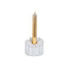 a white and gold candle holder with a flower on the bottom, in front of a white background