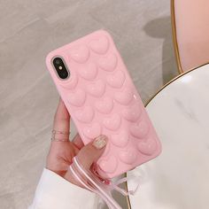 a person holding up a pink phone case