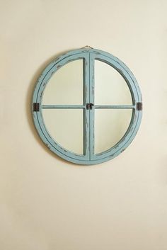 a round mirror mounted to the side of a wall