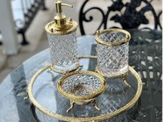 a glass table topped with two candles and a soap dispenser on top of it