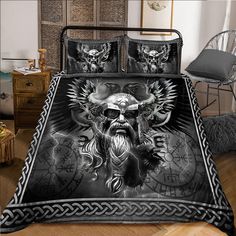 a bed covered in black and white sheets with an image of a man's face