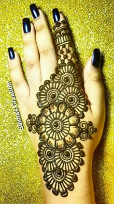 a henna tattoo on the palm of someone's hand with black nail polish