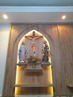 the wall is made up of wood and has statues of jesus, mary, jesus on the cross