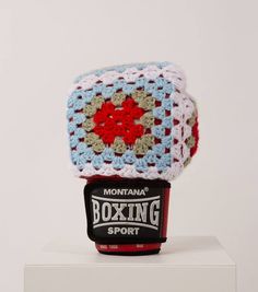 a crocheted hat sitting on top of a white box filled with boxing sport