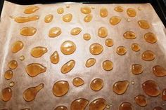 the pan is covered with brown liquid on top of baking sheet, and it looks like jelly drops