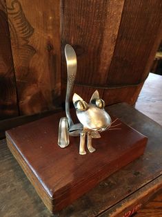 a metal cat figurine sitting on top of a wooden table