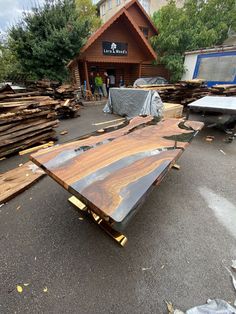 a table that is laying on the ground in front of a building with wood planks around it