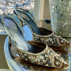 Elevate Your Look With These Gorgeous Gold Renee Caovilla Slingback Pumps. The Pointed Toe And Crystal Embellishments Add A Touch Of Elegance, Perfect For Any Formal Occasion Or Wedding. These Pre-Owned Heels Are In Excellent Shape And Will Fit A Us Shoe Size Of 8.5. The Vintage Style Of These Shoes Make Them A Unique Addition To Any Wardrobe, Especially For Those Who Appreciate High-End Designer Brands. Don't Miss Out On The Opportunity To Add These Stunning Heels To Your Collection Today. (Wor Luxury Slingback Pumps For Party With 4-inch Heel, Designer Crystal-embellished Slingback Pumps For Formal Occasions, Embellished Slingback Heels For Gala, Designer Formal Slingback Pumps With Crystals, Luxury Slingback Pumps For Party, Glamorous Embellished Slingback Pumps For Gala, Embellished Slingback Pumps For Formal Occasions, Elegant High Heel Slingback Pumps For Cocktail, Elegant Embellished Ankle Strap Heels