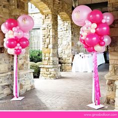 some pink and white balloons are in the middle of a walkway with other decorations on it