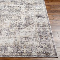 an area rug on the floor with wooden floors and hardwooding in the background,